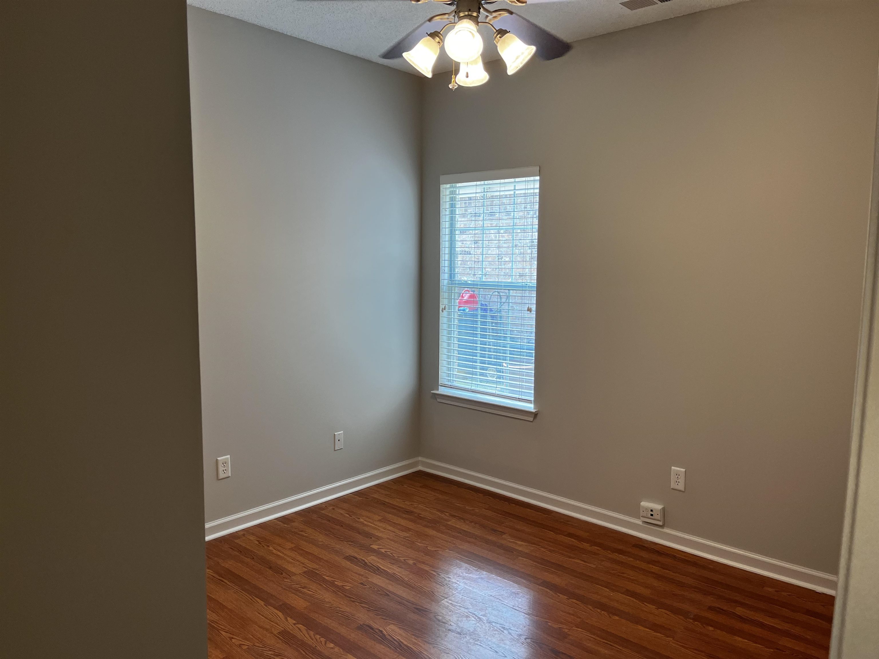 1182 Collierville Arlington Road Collierville, TN 38017 - Photo 8 of 34 an empty room with wooden floor and windows