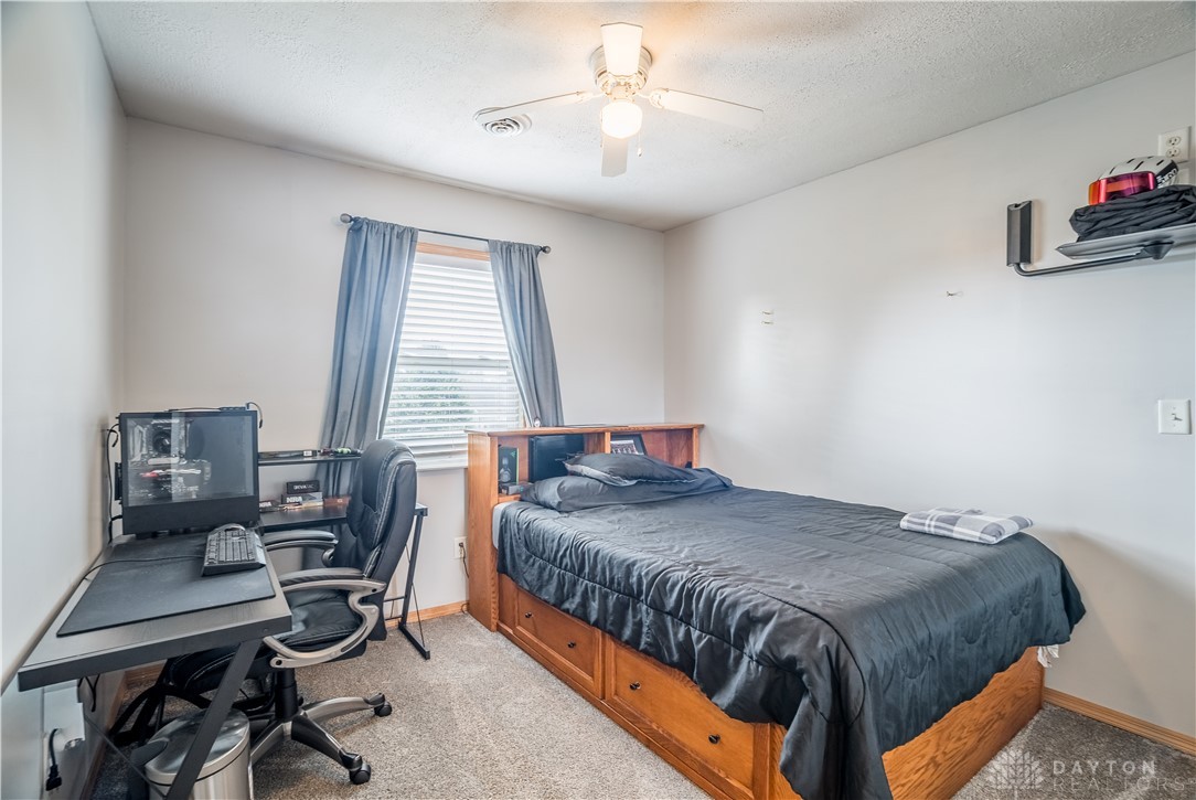 1442 Langdon Road Sidney, OH 45365 - Photo 27 of 34 This cozy bedroom features comfortable carpeting and a functional ceiling fan for optimal comfort.