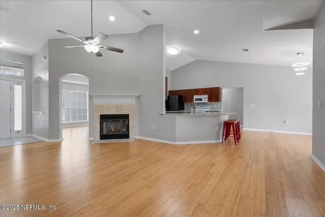a view of a livingroom with a fireplace a chandelier and wooden floor