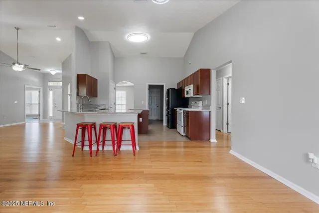 a kitchen with stainless steel appliances kitchen island granite countertop a stove and a view of living room