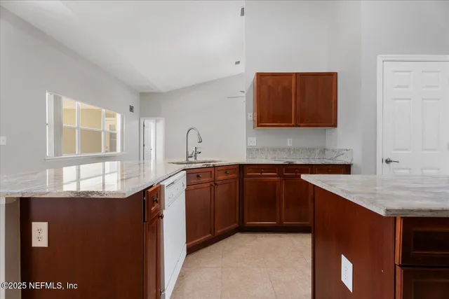 a kitchen with stainless steel appliances granite countertop a sink and a stove next to a window