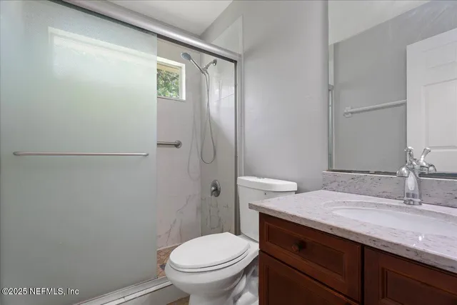 a bathroom with a granite countertop toilet and a sink