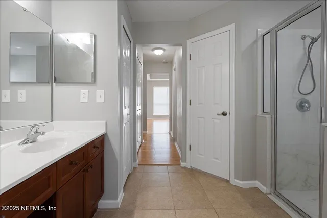 a spacious bathroom with a shower sink and mirror