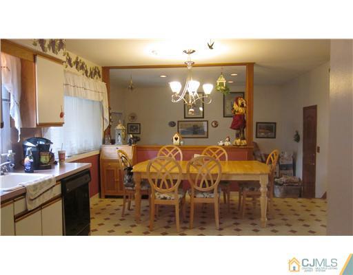 57 South Cliff Road Colonia, NJ 07067 - Photo 4 of 15 a kitchen with a dining table chairs and a white counter top