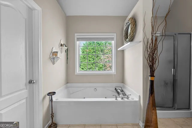 a bathroom with a tub a window and a shower