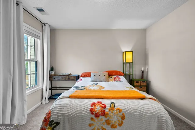 a bed sitting in a bedroom next to a window