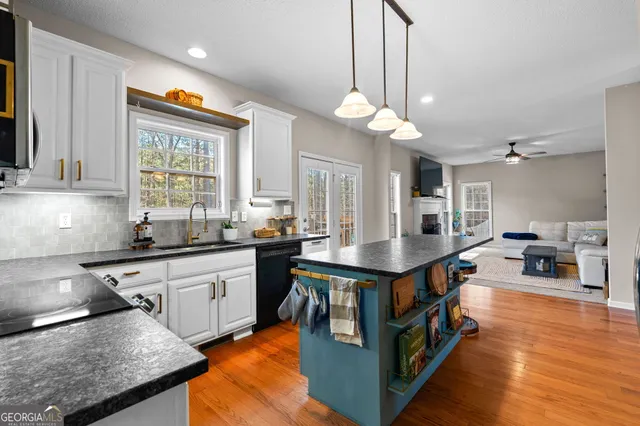 a kitchen with stainless steel appliances granite countertop a stove and cabinets