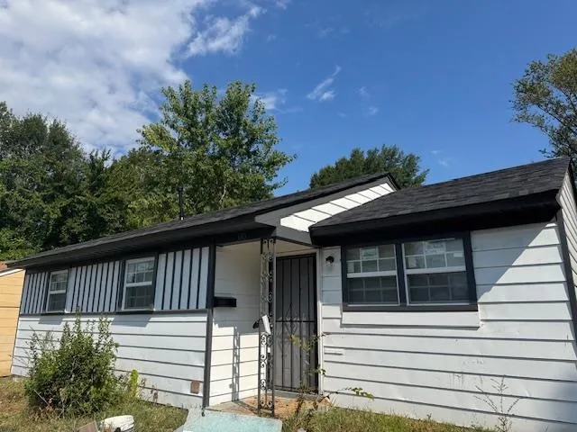 a view of house with a large window and wooden fence