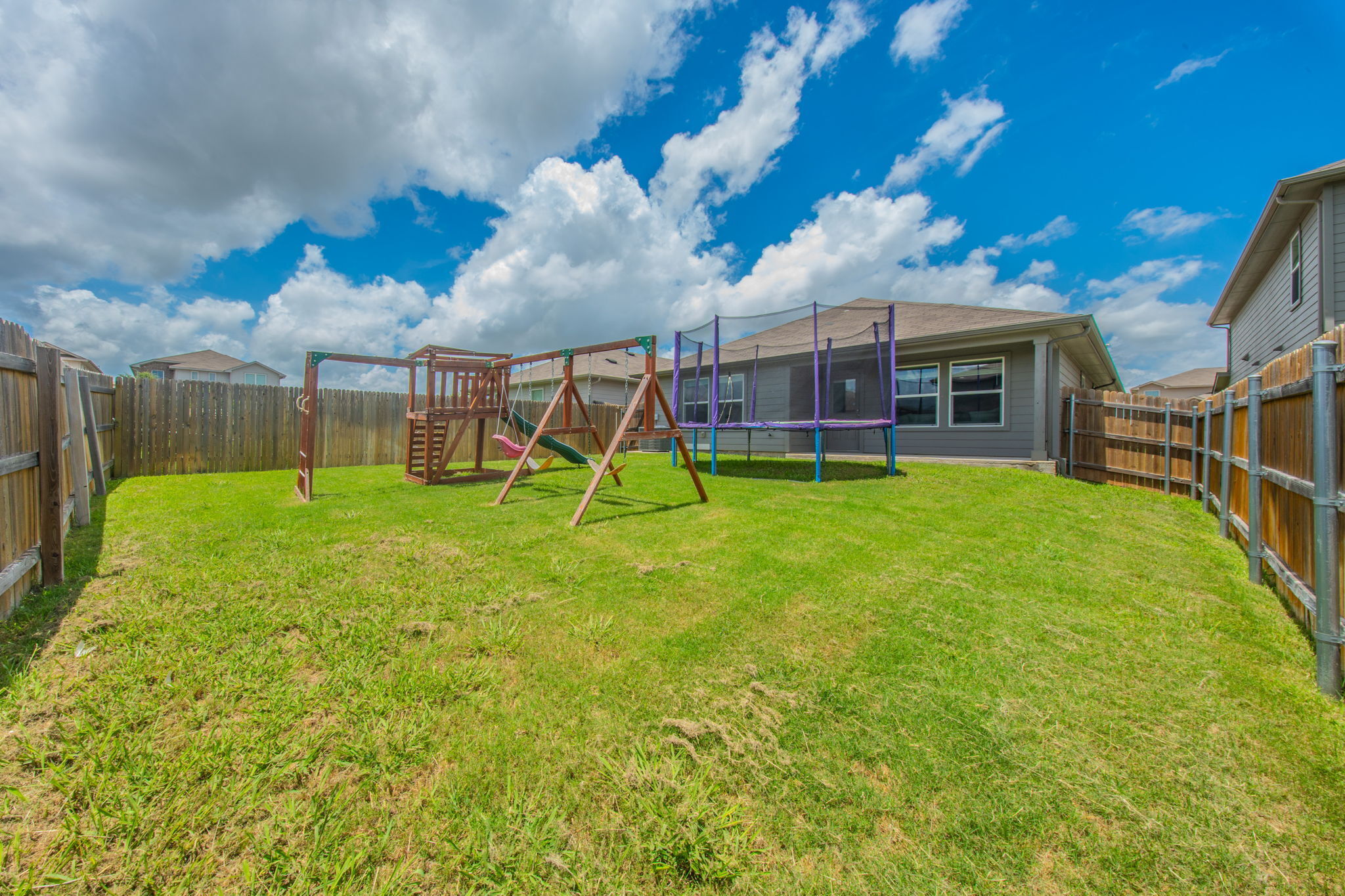 14903 Tuff Road Manor, TX 78653 - Photo 22 of 25 A spacious backyard with mature green grass, perfect for play and relaxation.