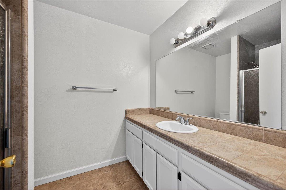 4875 North Backer Avenue, Unit 143 Fresno, CA 93726 - Photo 23 of 27 a bathroom with a granite countertop sink and a mirror