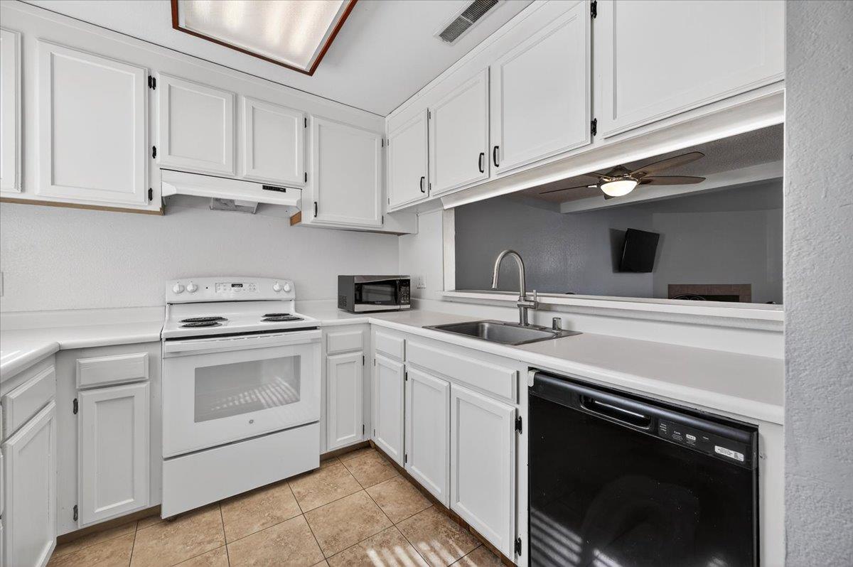 4875 North Backer Avenue, Unit 143 Fresno, CA 93726 - Photo 6 of 27 a kitchen with white cabinets and white appliances