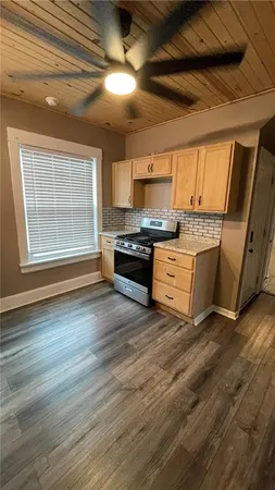 a kitchen with stainless steel appliances wooden floors and a stove