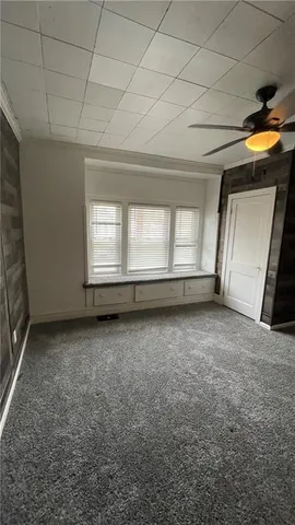 an empty room with a fireplace and windows