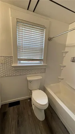 a white toilet sitting next to a bath tub