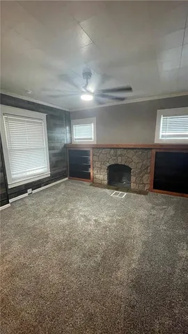 an empty room with a fireplace and window