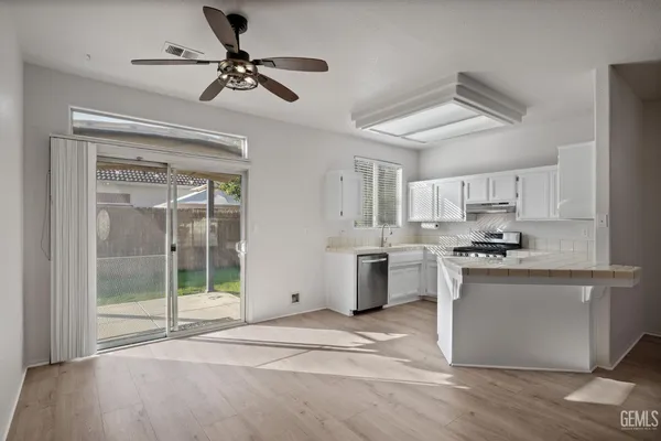 a kitchen with stainless steel appliances granite countertop a stove a refrigerator a sink and a chandelier