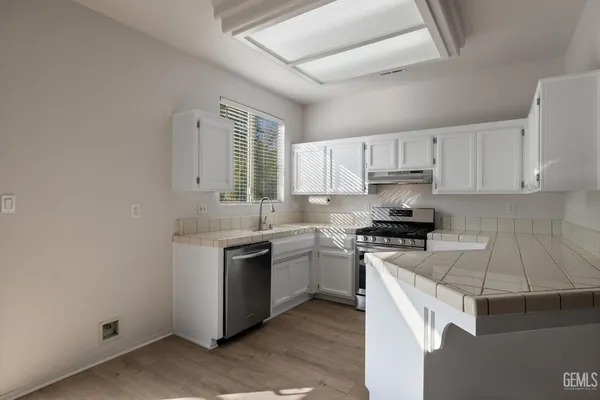 a kitchen with a stove sink and cabinets