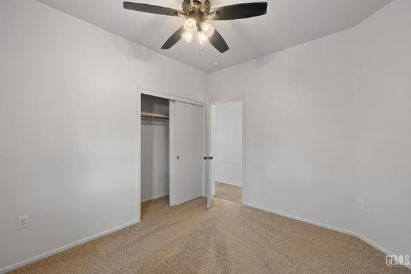 an empty room with chandelier fan