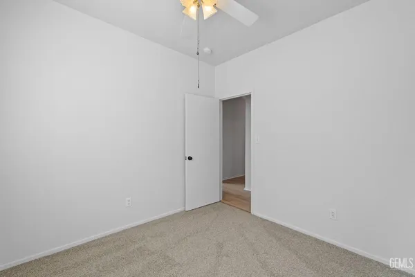 a view of a room with a chandelier fan