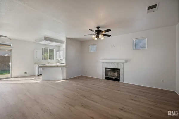 a view of a livingroom with a fireplace a sink and dishwasher with wooden floor