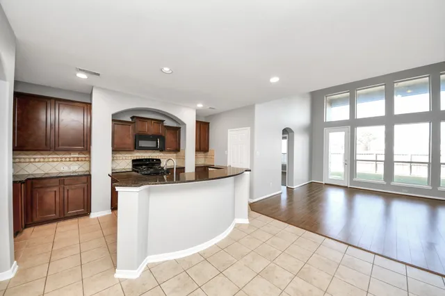 a kitchen with stainless steel appliances granite countertop a refrigerator and a stove top oven