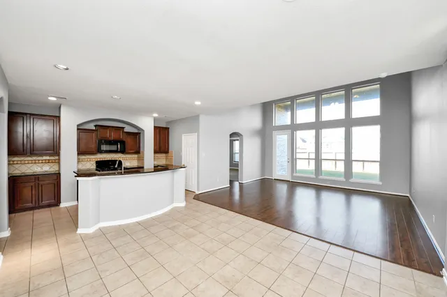 a large space with a large window and kitchen view