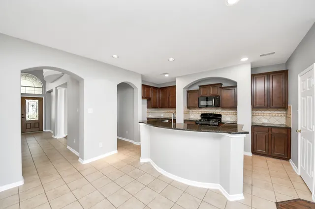 a kitchen with stainless steel appliances granite countertop a refrigerator and a stove top oven