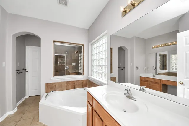 a bathroom with a bathtub a sink and a window