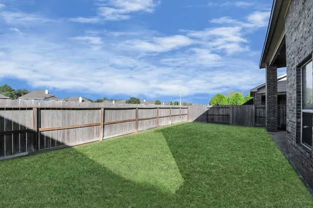 a view of a backyard with wooden fence