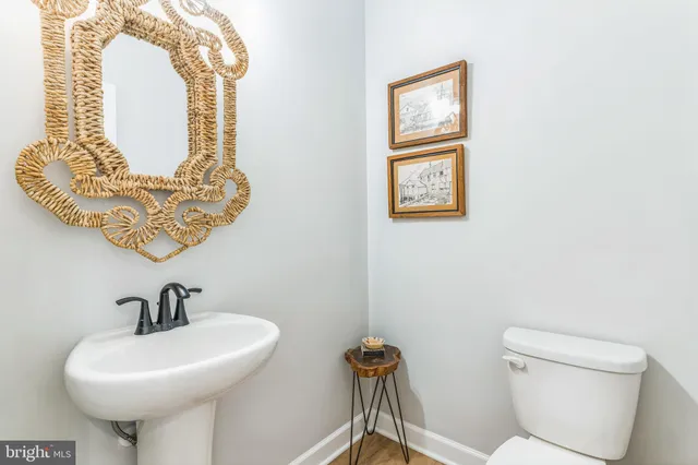 a bathroom with a toilet a sink and mirror