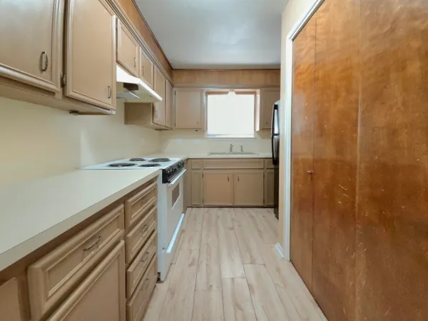 a kitchen with a sink a stove and cabinets