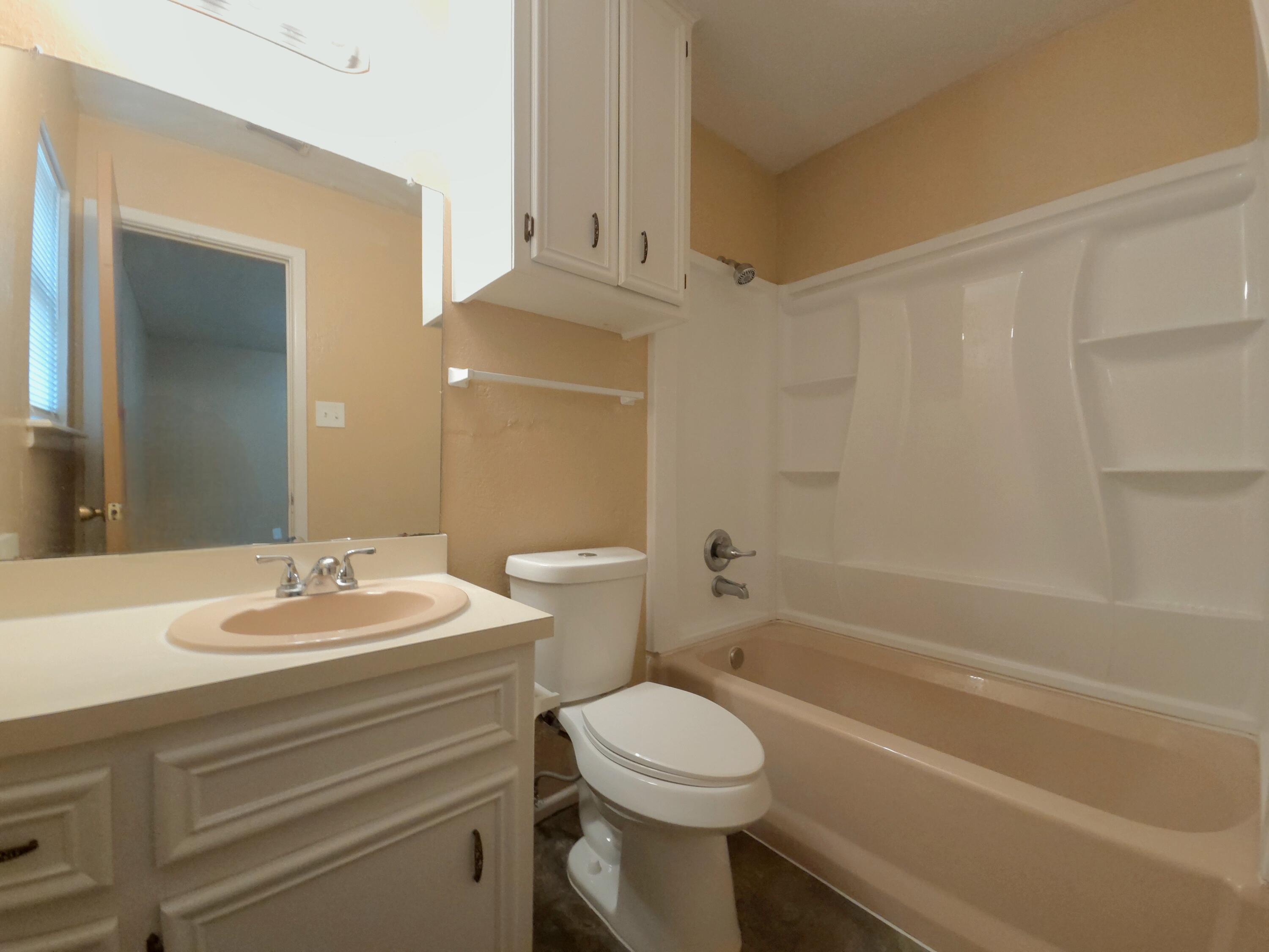 1608 28th Street Lubbock, TX 79411 - Photo 10 of 10 a bathroom with a sink a toilet and shower