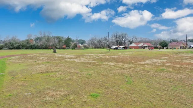 a view of a field with an trees in the background