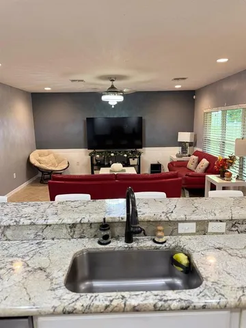 a kitchen with a sink a stove and chairs