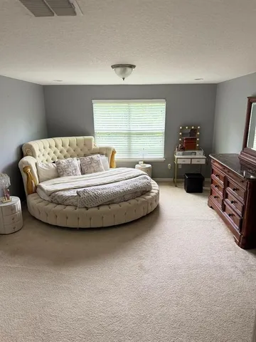 a spacious bedroom with a bed and a window