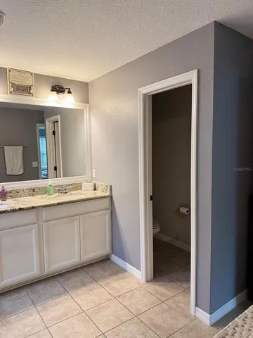 a spacious bathroom with a granite countertop sink and a mirror