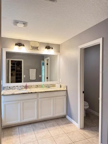 a spacious bathroom with a granite countertop sink and mirror