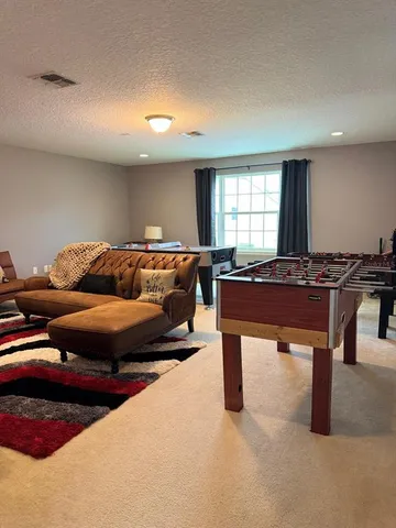 a living room with furniture and a pool table