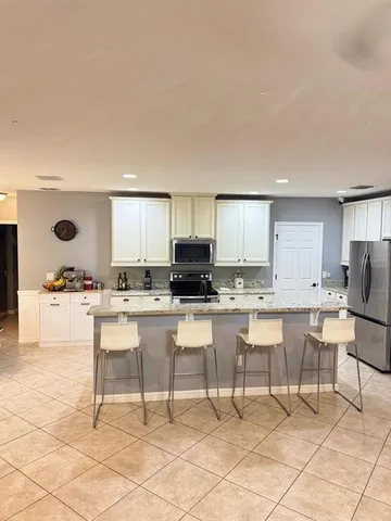 a kitchen with a dining table chairs and a refrigerator