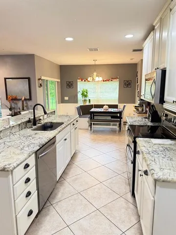 a open kitchen with stainless steel appliances kitchen island granite countertop a sink and cabinets