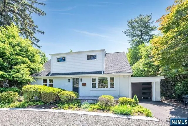 a front view of a house with a yard and potted plants