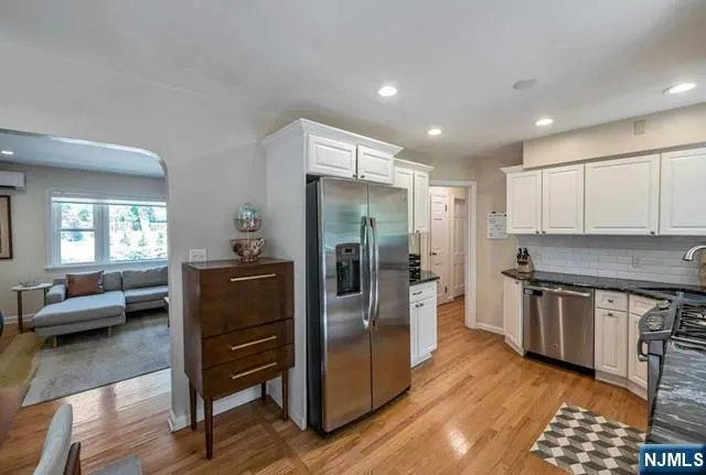 a kitchen with stainless steel appliances granite countertop a refrigerator and a stove top oven