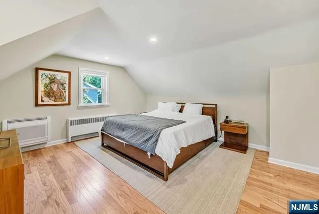 a bedroom with a large bed and a painting on the wall