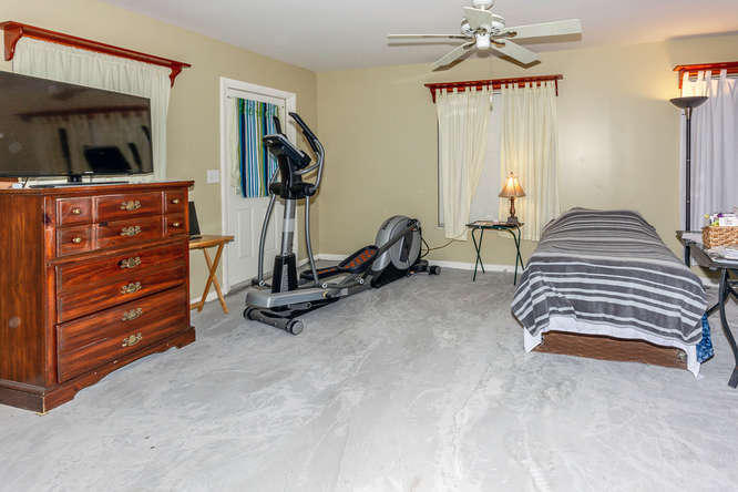308 Masters Road Palm Springs, FL 33461 - Photo 6 of 18 a room with gym equipment and a flat screen tv