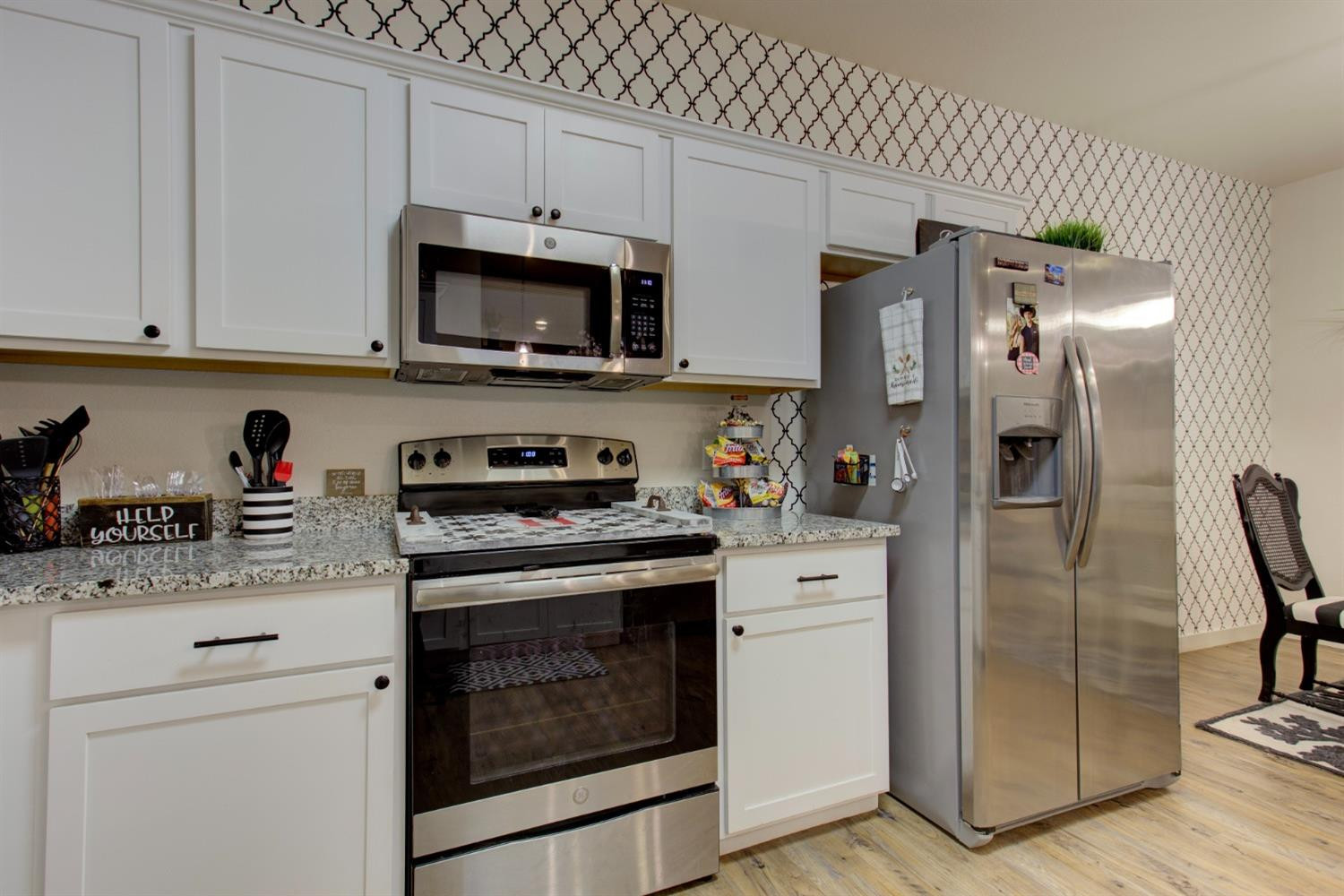 2721 137th Street Lubbock, TX 79423 - Photo 4 of 30 a kitchen with stainless steel appliances granite countertop a refrigerator stove and white cabinets