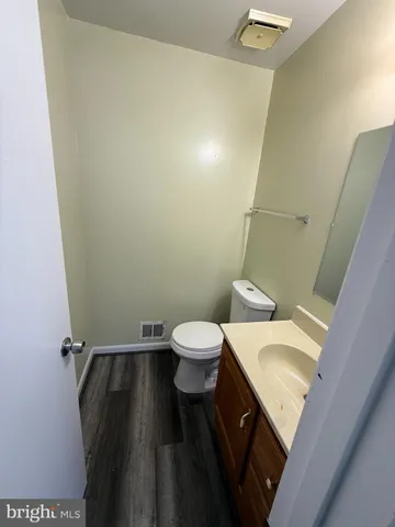 a bathroom with a granite countertop toilet sink and a mirror