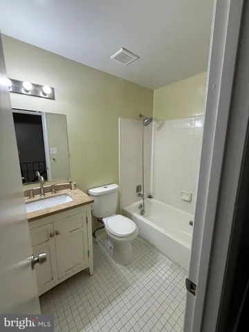 a bathroom with a double vanity sink toilet mirror and bathtub