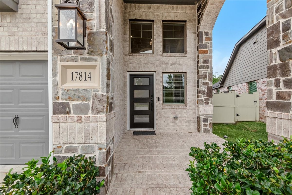 17814 Tree Of Heaven Conroe, TX 77385 - Photo 12 of 48 Impressive covered front entry with soaring ceilings, stone and brick accents, and a grand, welcoming presence.