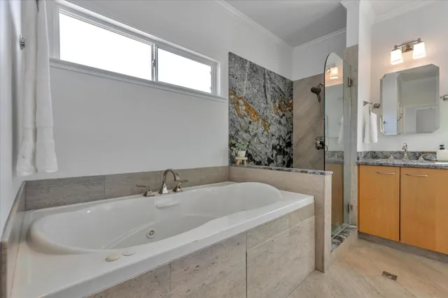 a bathroom with a tub sink and mirror