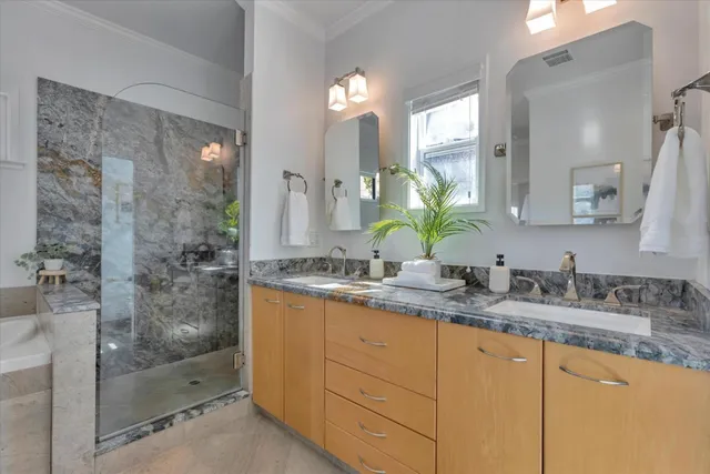a bathroom with a granite countertop sink a mirror and a shower